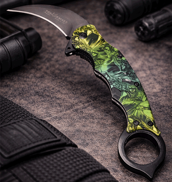 Cuchillo Karambit táctico con hoja curva de acero y mango camuflado ergonómico. Diseño compacto con anillo de seguridad, ideal para uso outdoor, camping y actividades tácticas.